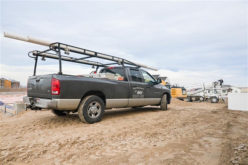 Crew screeding and leveling concrete slab for commercial construction