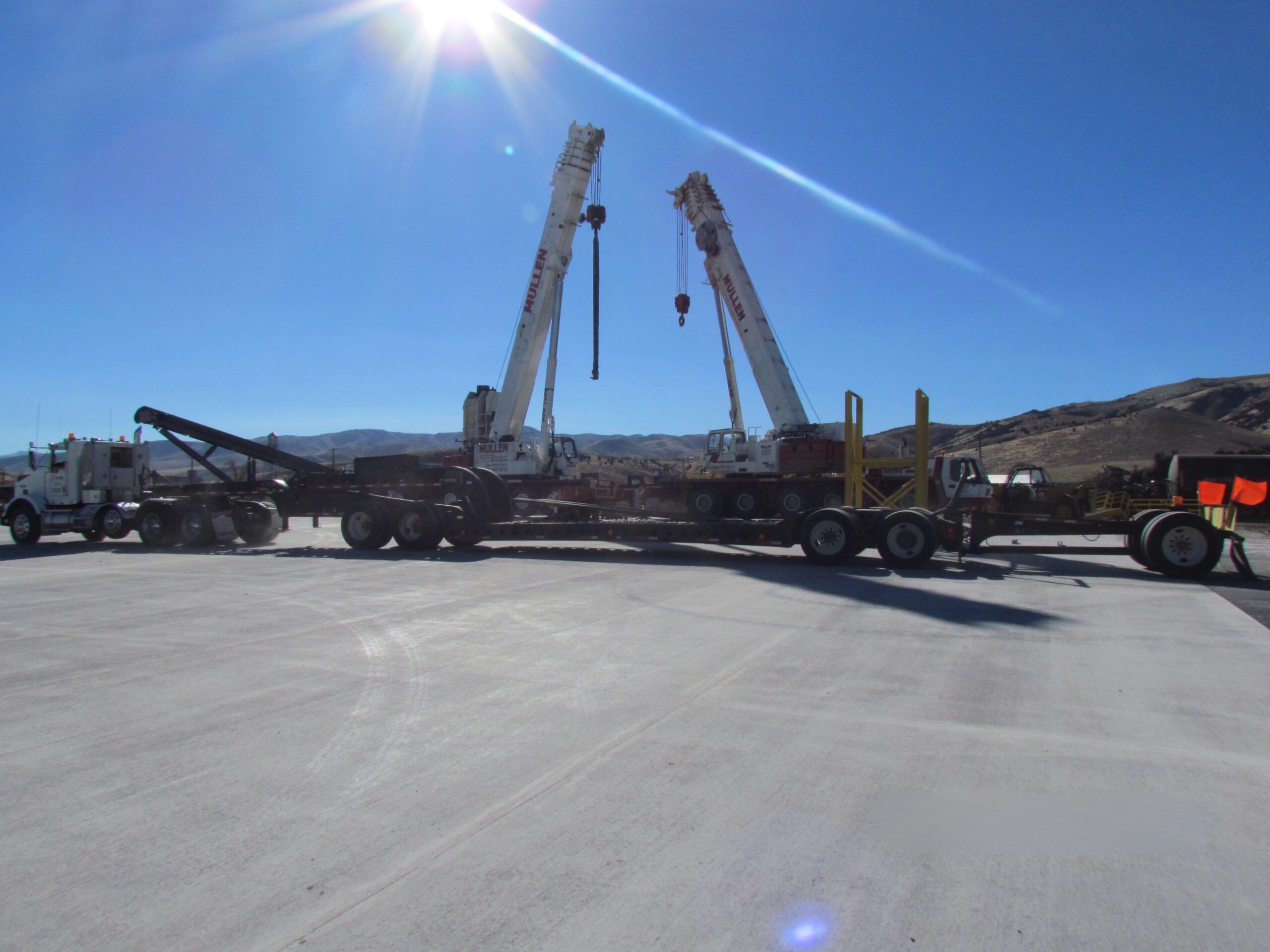 Cranes positioned for commercial structural coordination on construction site